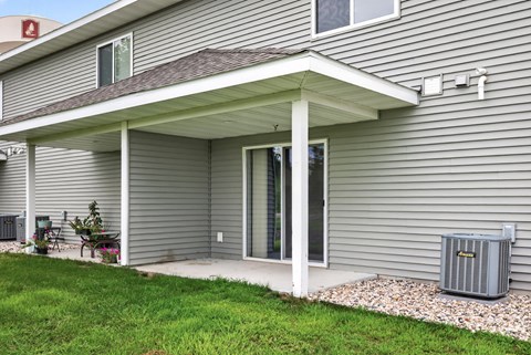 A house with a grey siding and a covered patio area.