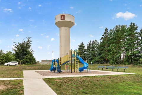 A playground with a water tower in the background.