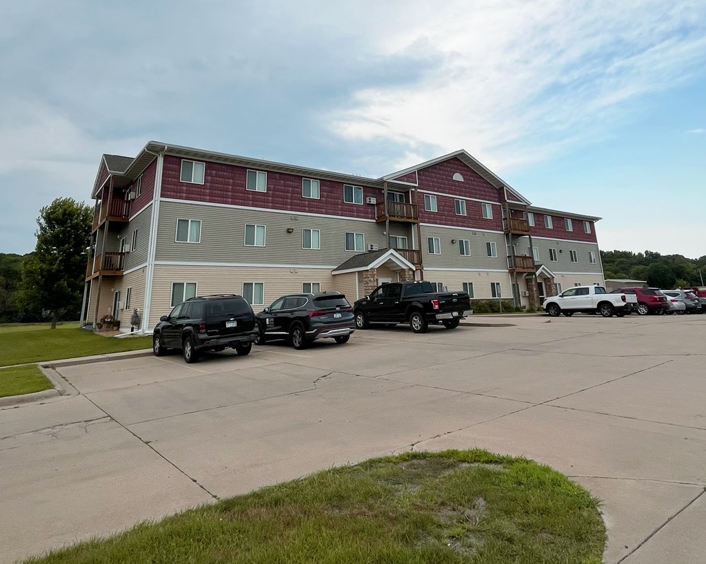 Two black trucks parked in front of a red and white building.
