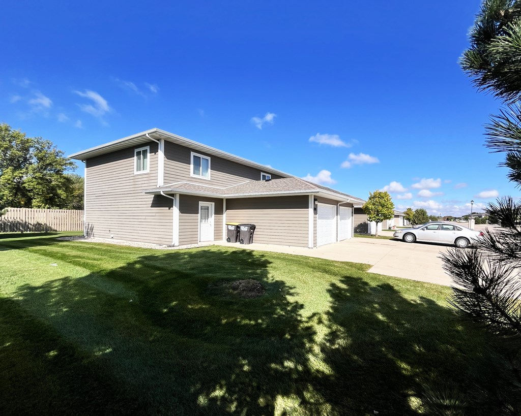 A house with a grey roof and a green lawn in front.