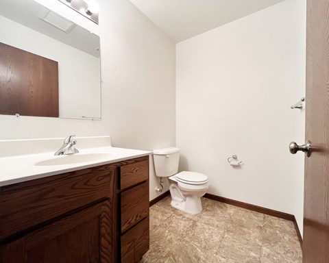 A white toilet sits in a bathroom next to a sink.