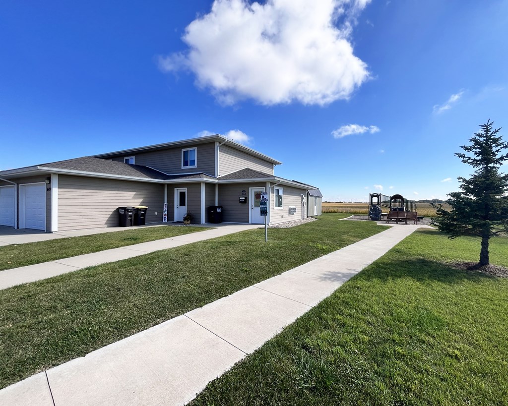 A house with a well-maintained lawn and a clear blue sky.