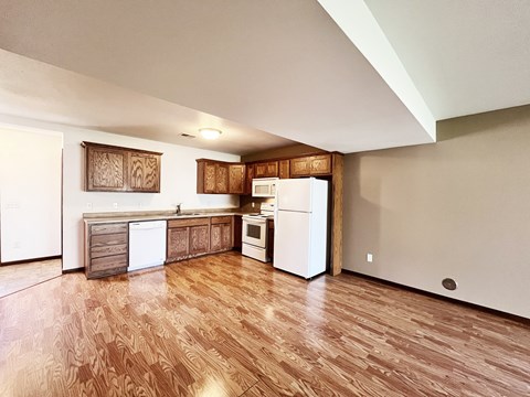 A kitchen with wooden floors and white appliances.