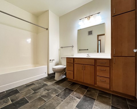 A bathroom with a toilet, sink, and a walk-in shower.