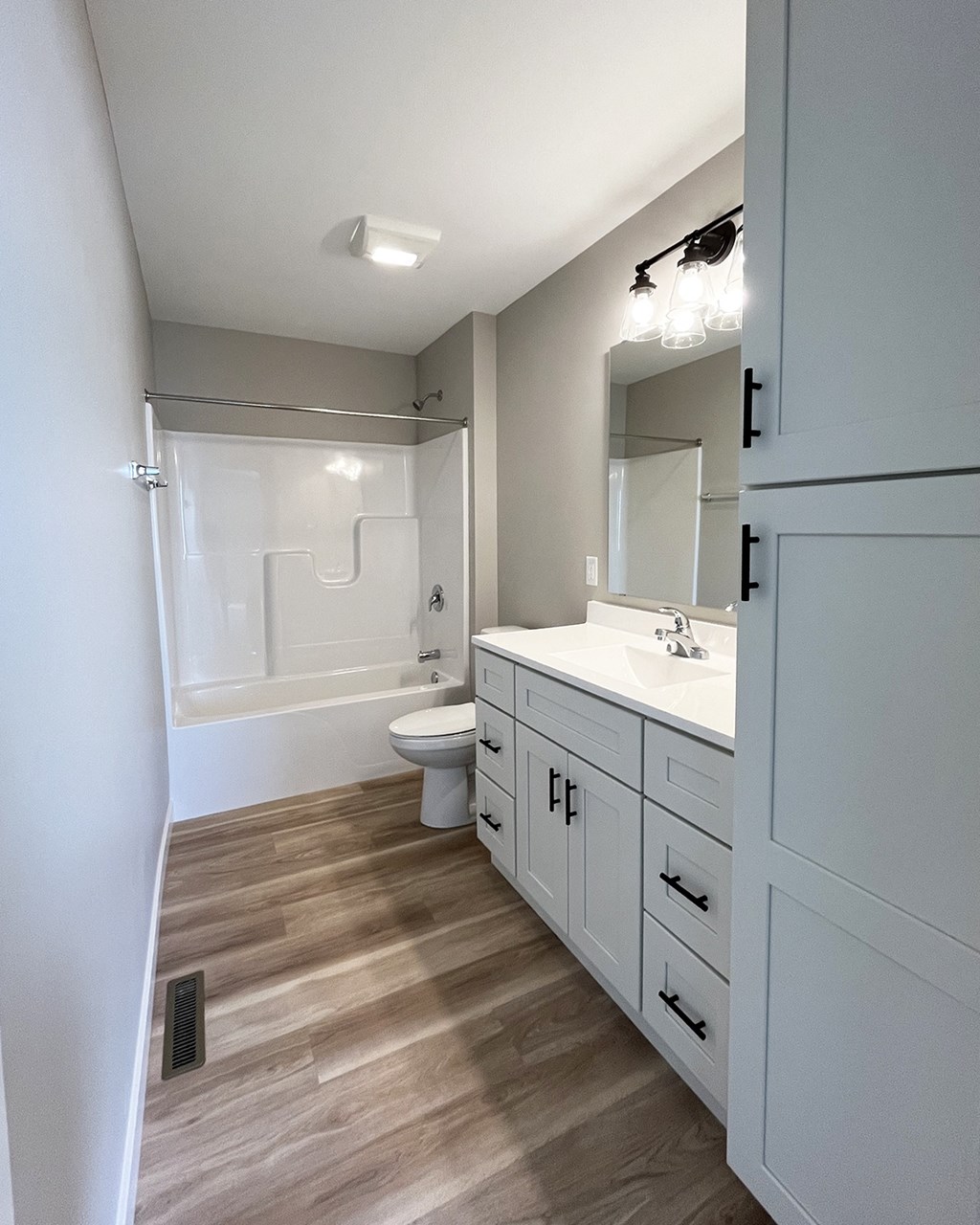 a bathroom with white cabinets and a sink and a toilet