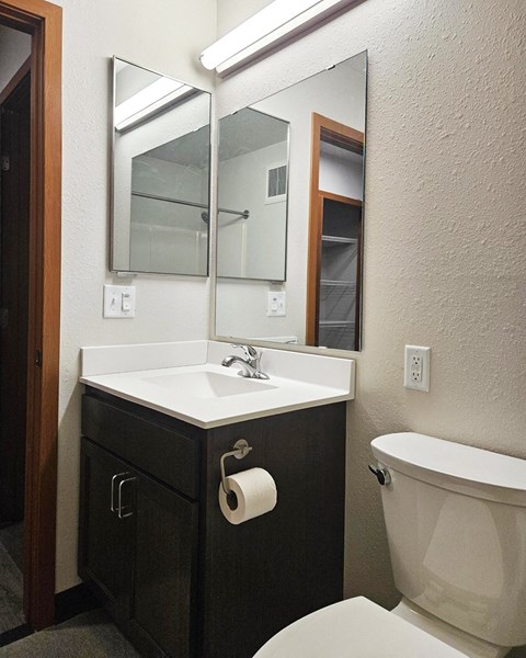 A bathroom with a white sink and a white toilet.