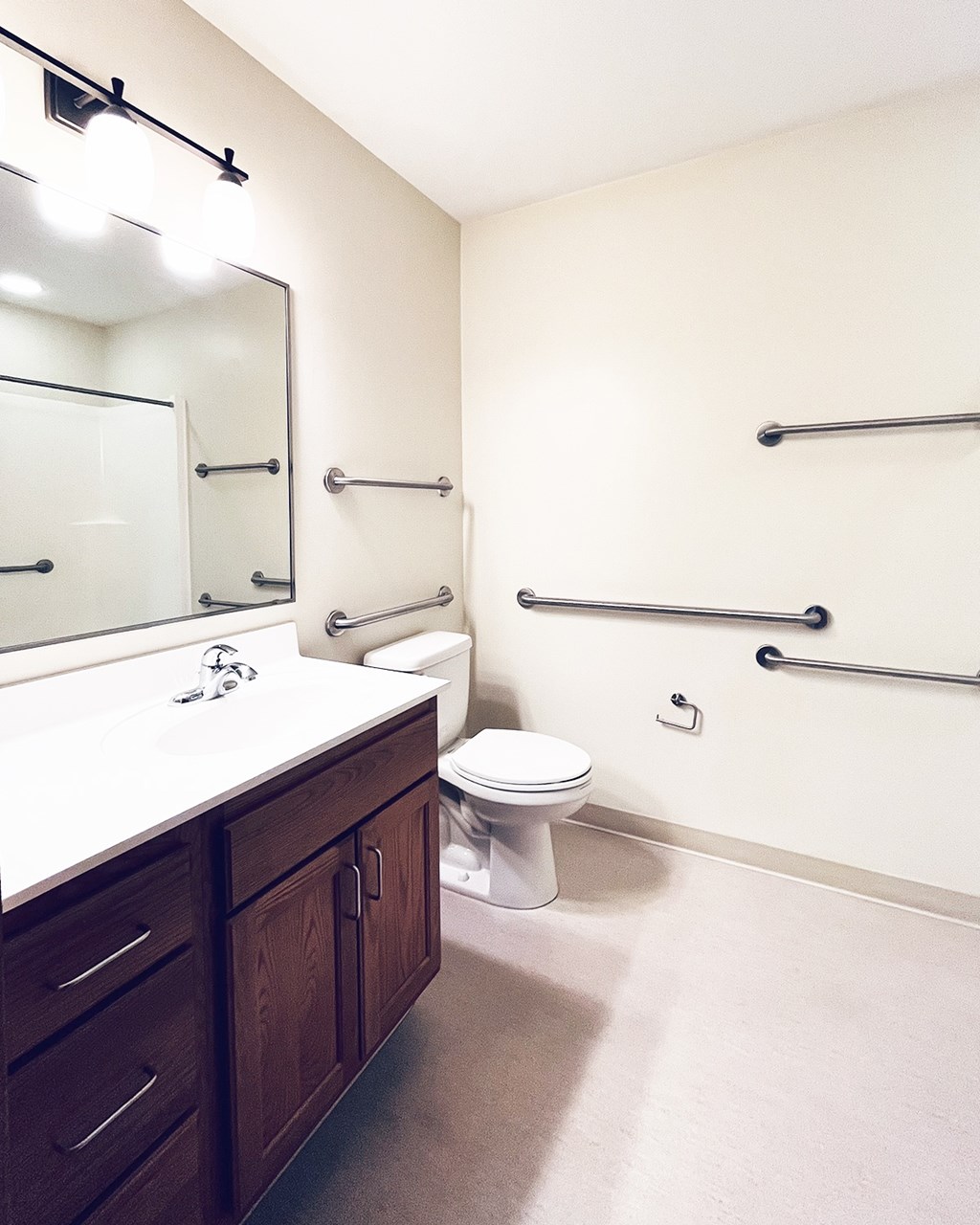 A white sink with a mirror above it and a toilet in the corner.