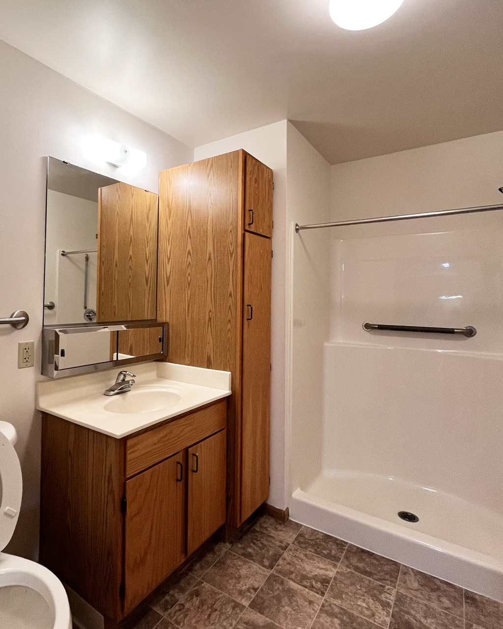 A bathroom with a toilet, sink, and shower.