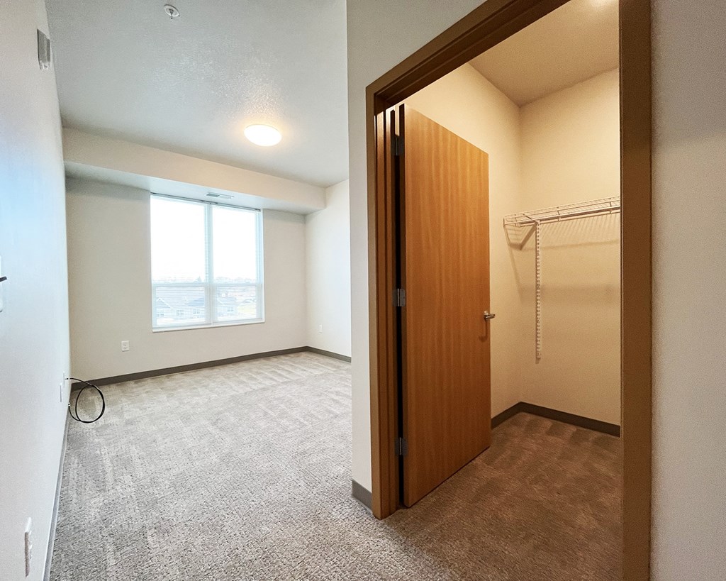 A room with a carpeted floor and a wooden door.
