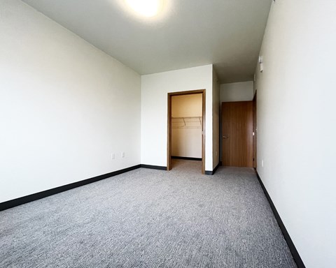 A room with a carpeted floor and a wooden door.