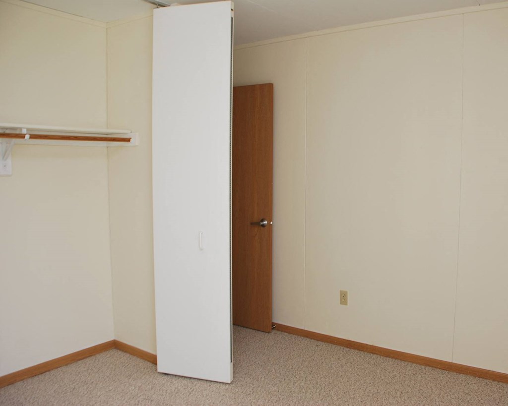 an empty room with a closet and a door