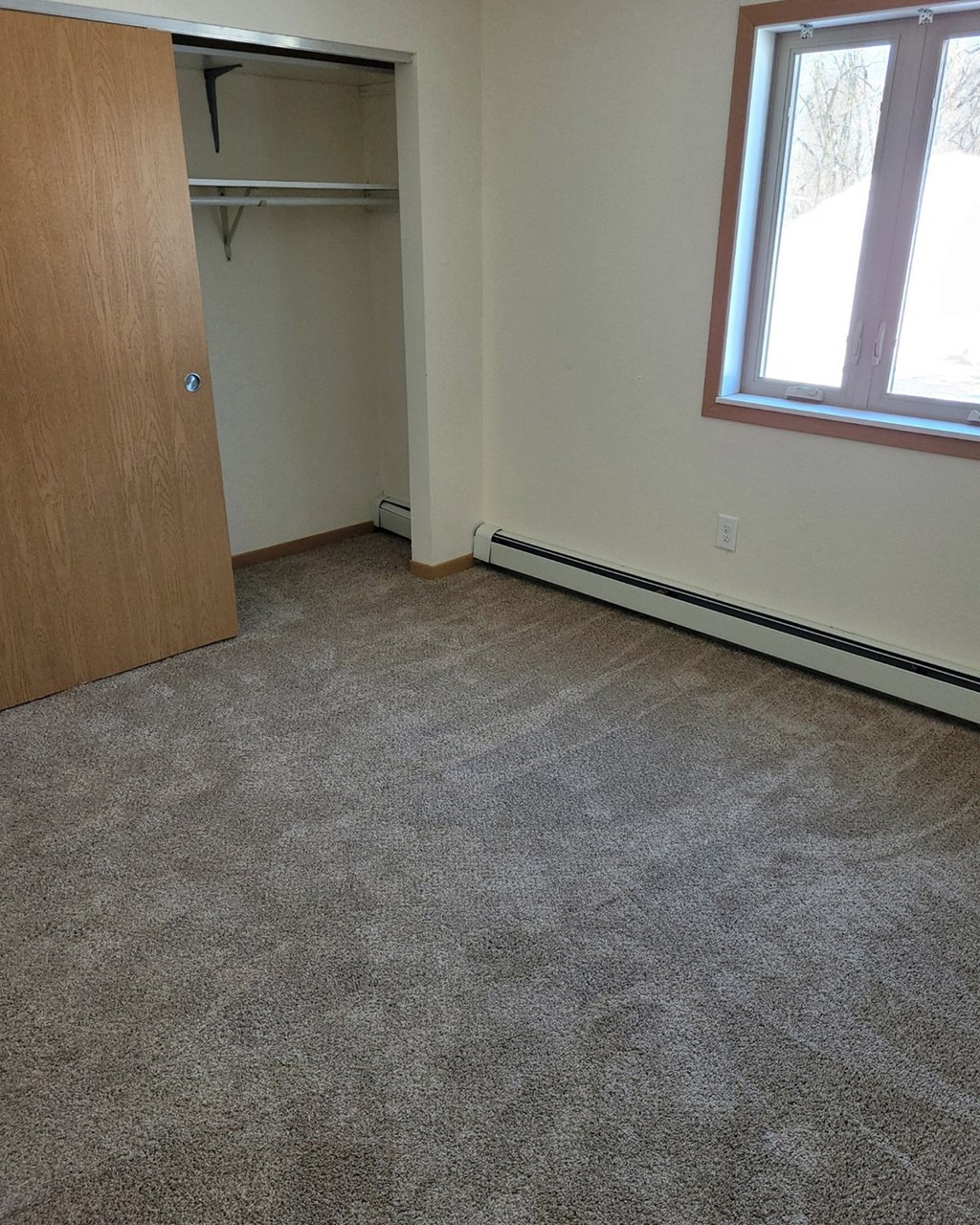 a room with a carpeted floor and a door to a closet