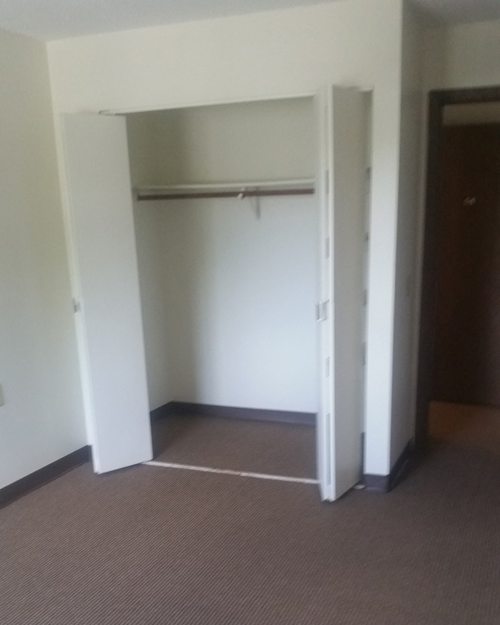 an empty room with a closet and a door