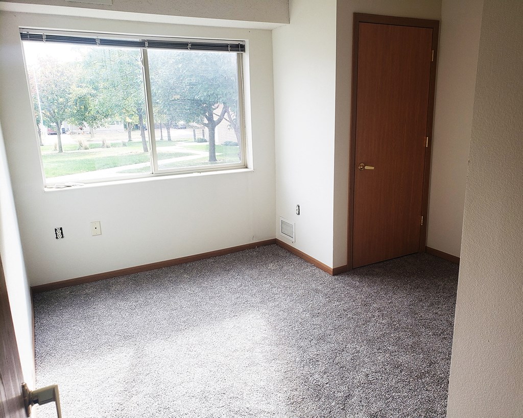 an empty room with a window and a door