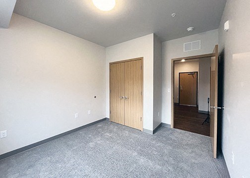 an empty living room with a door to a hallway