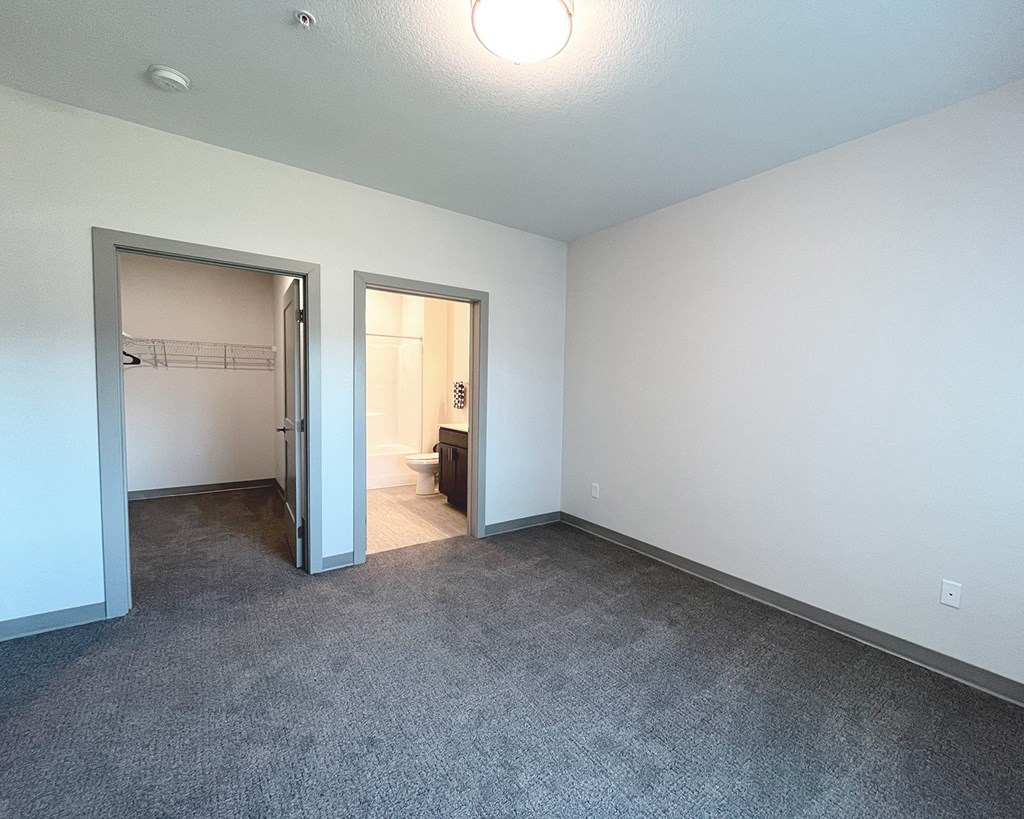 an empty living room with a door to a bathroom