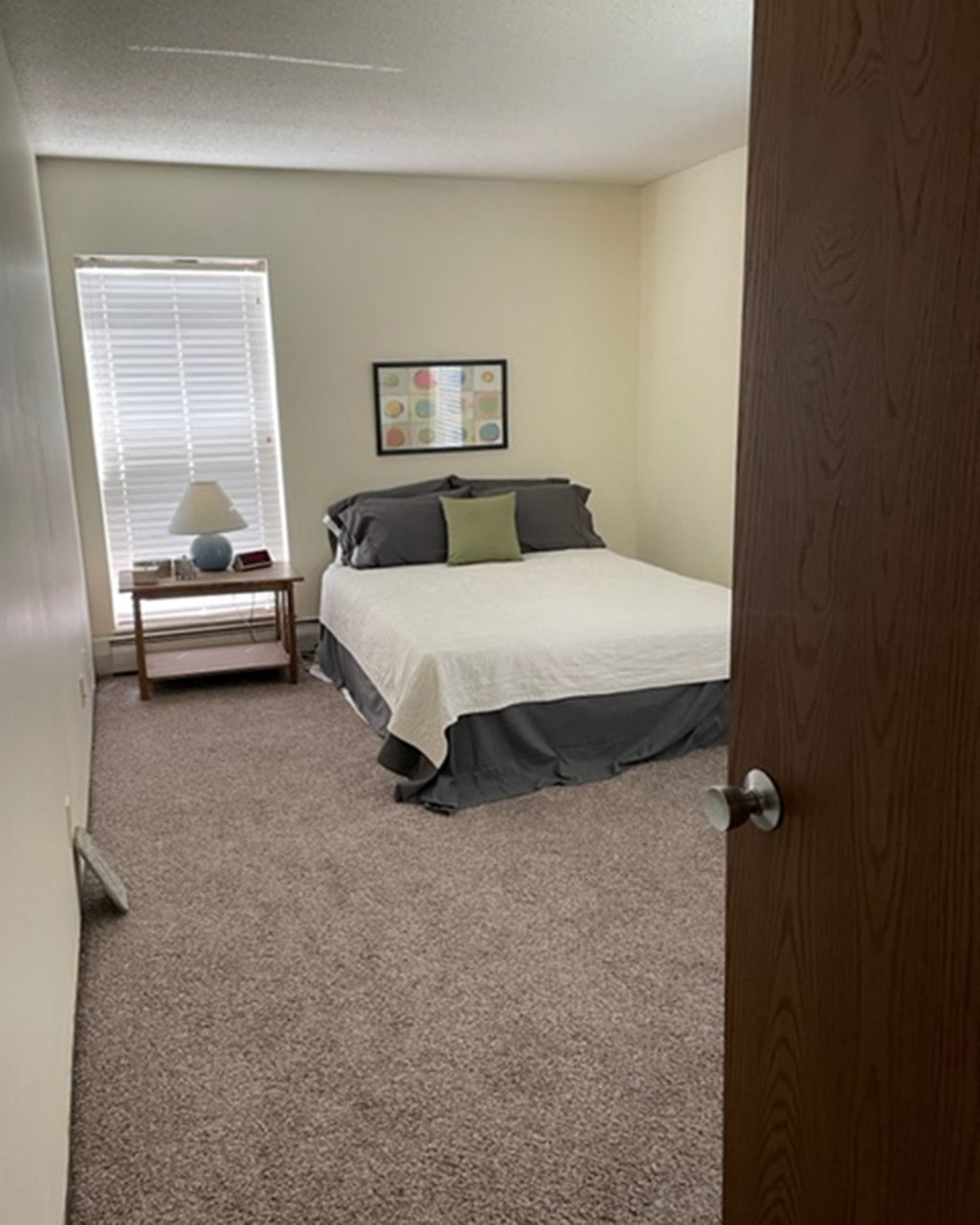 a bedroom with a bed and a nightstand and a window