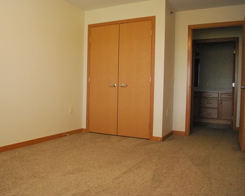 a bedroom with a closet and a door to a hallway