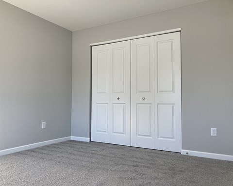 A room with a white door and carpeted floor.