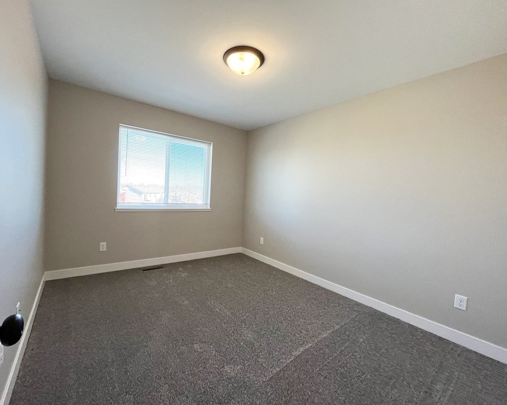 an empty room with carpet and a window