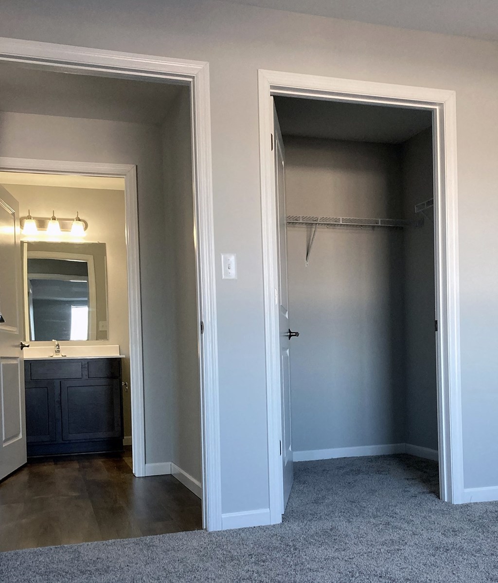 a bedroom with a closet and a door to a bathroom