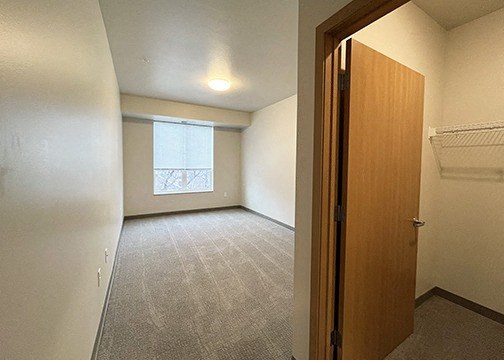an empty room with a closet and a window