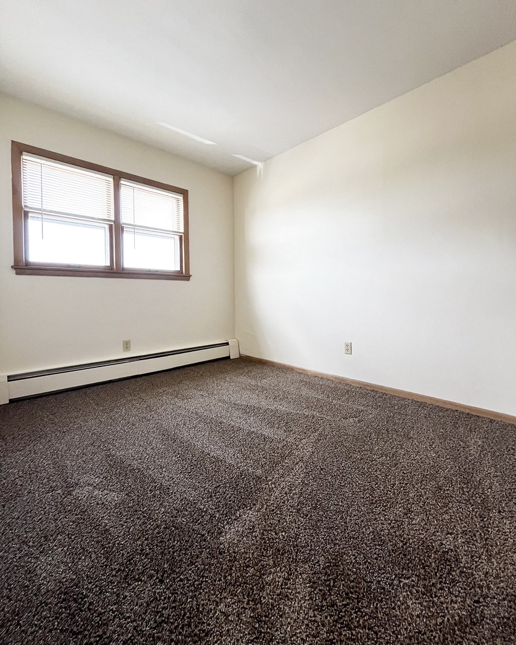an empty room with carpet and a window