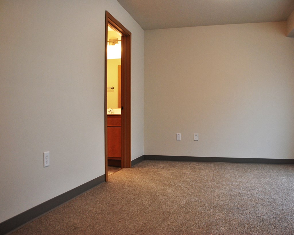 an empty room with a doorway to a bathroom