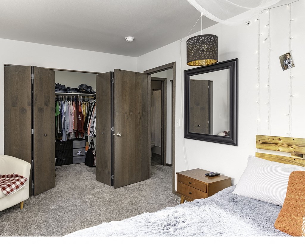 a bedroom with a bed and a mirror and a closet