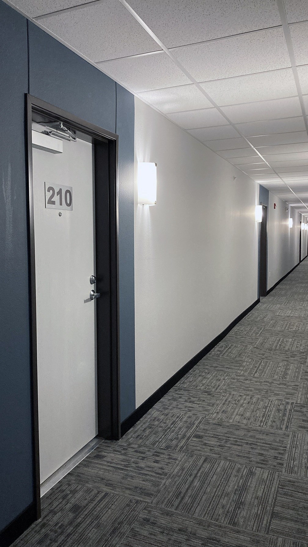 A hallway with a door numbered 210.