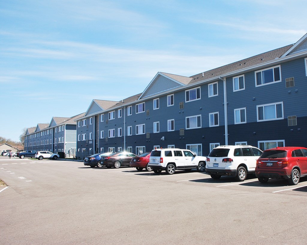 A parking lot with cars and a building in the background.