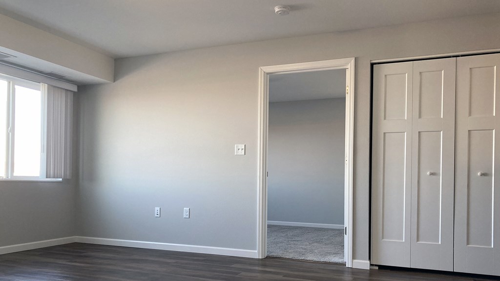 A room with a grey wall and a white door.