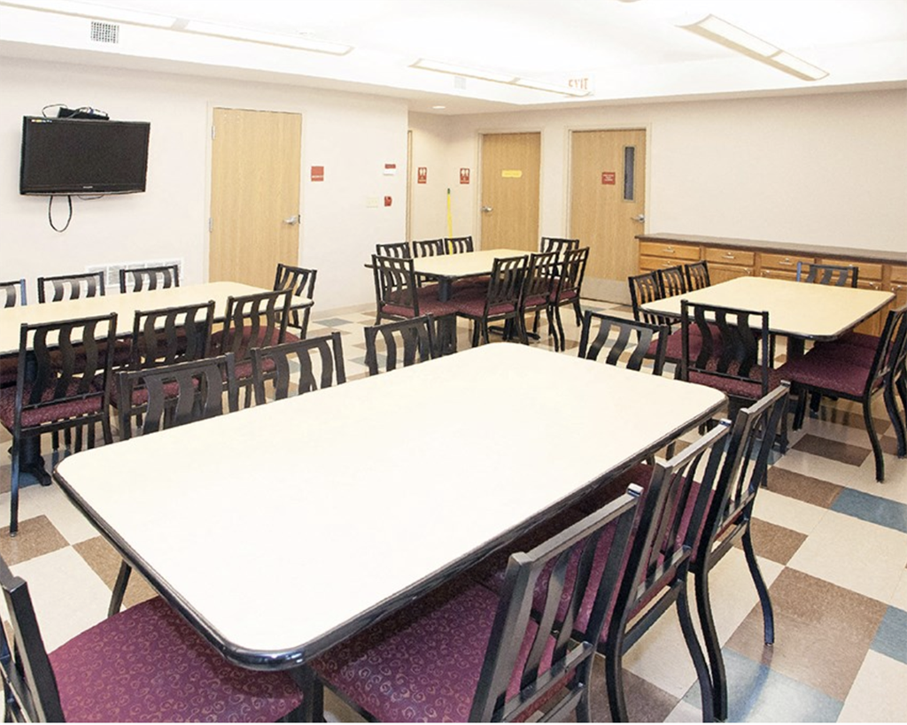 A white table surrounded by chairs in a room.