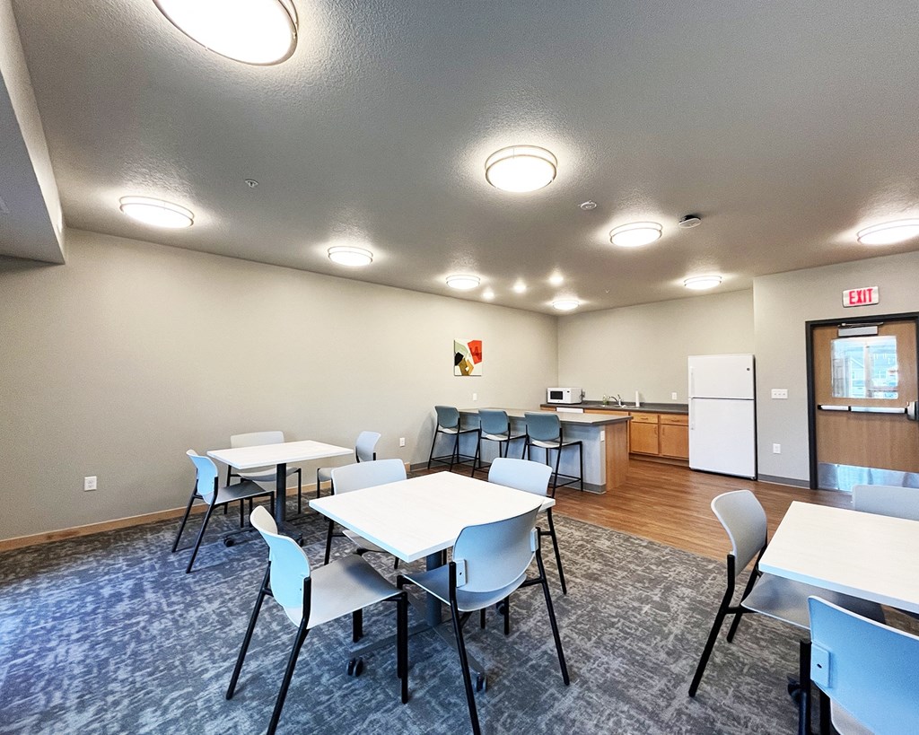 A conference room with a white table and chairs.