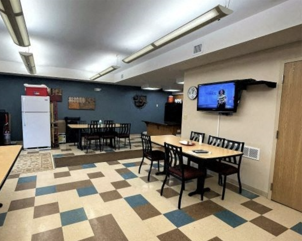 A room with a checkered floor and a television mounted on the wall.