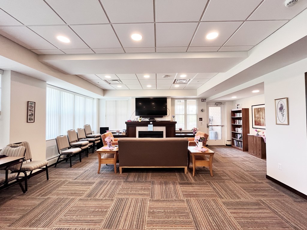 A waiting room with a brown carpet and wooden furniture.