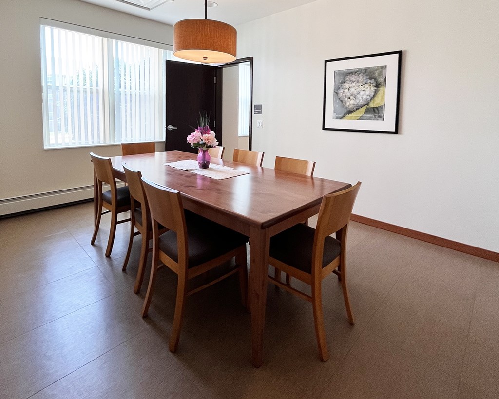 A dining room with a wooden table and chairs.