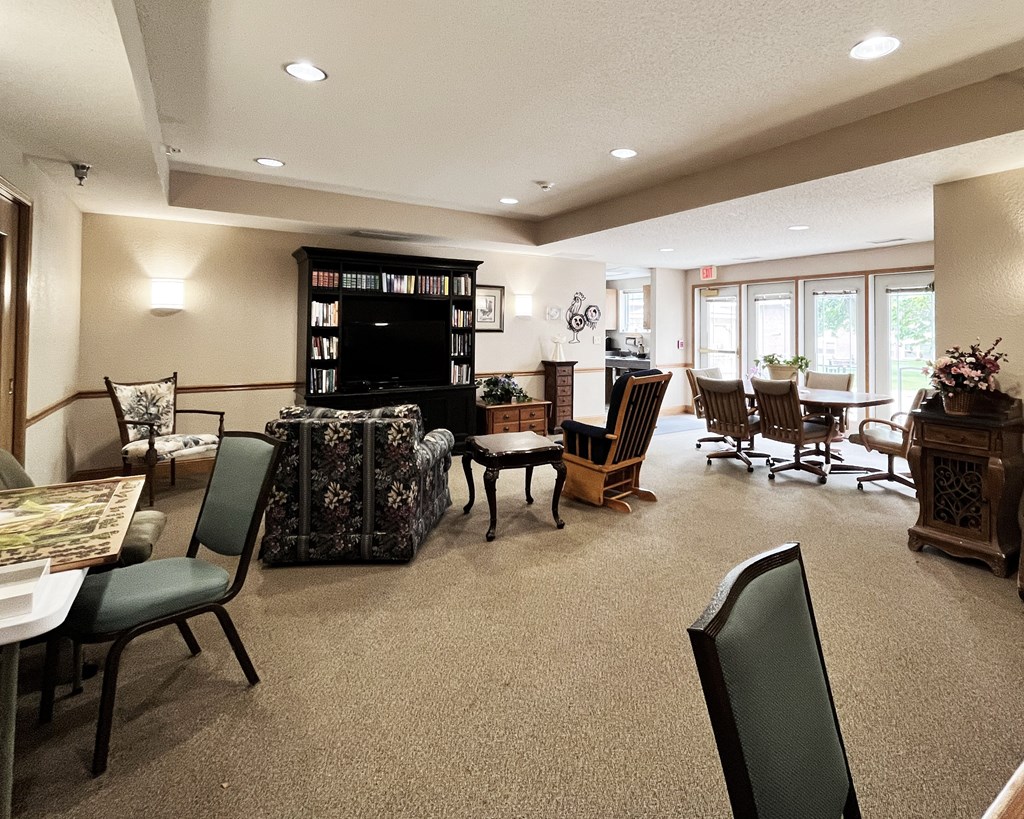A living room with a black bookcase filled with books.