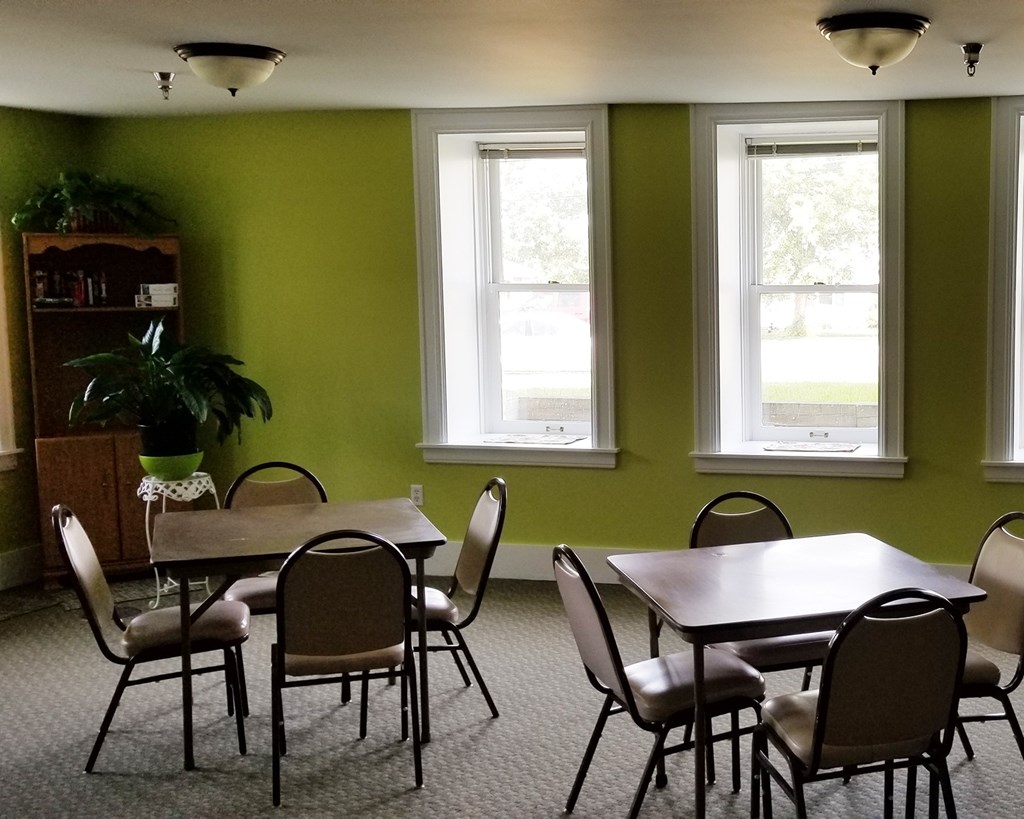 A dining room with a table and chairs.