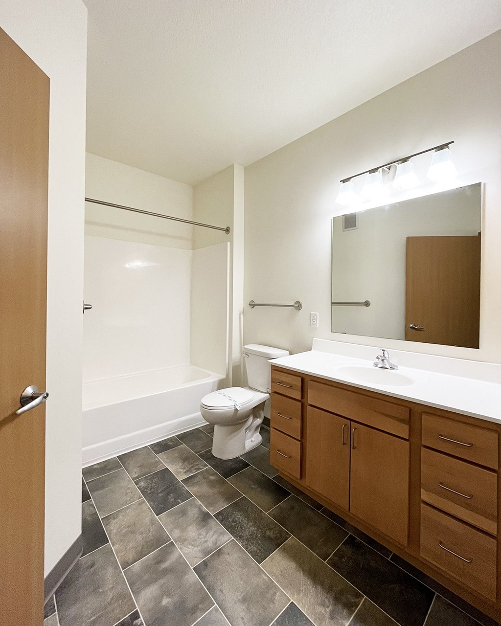 A bathroom with a toilet, sink, and mirror.