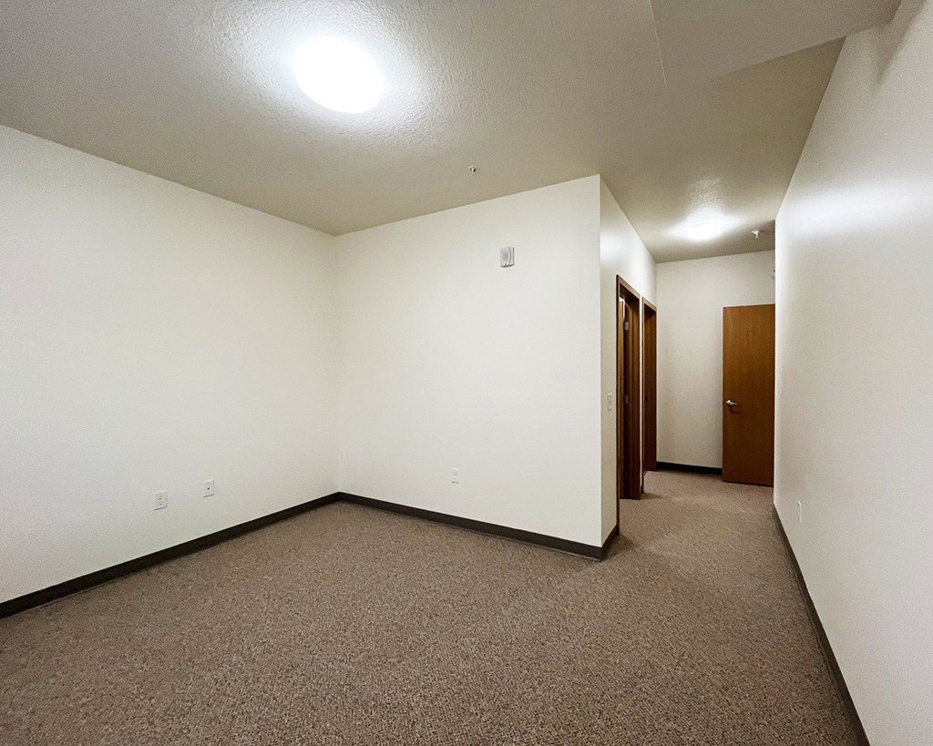 A room with carpeted floor and white walls.