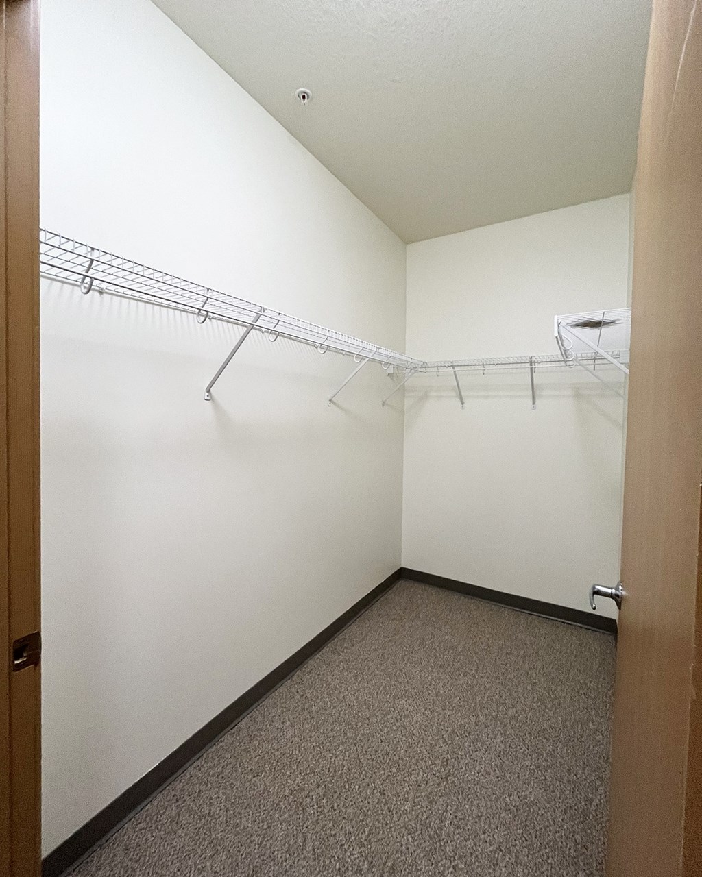 A white wall with a metal rack on it.