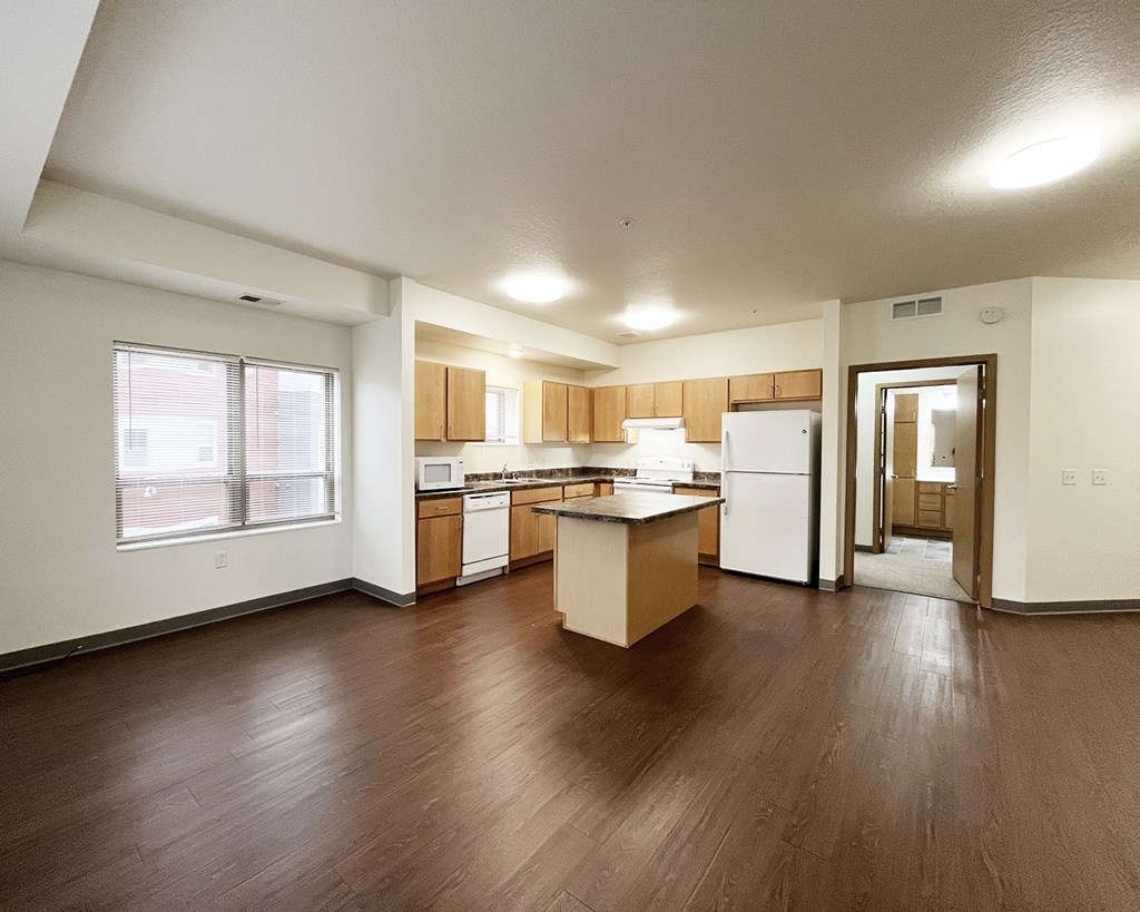 A kitchen with wooden floors and white appliances.