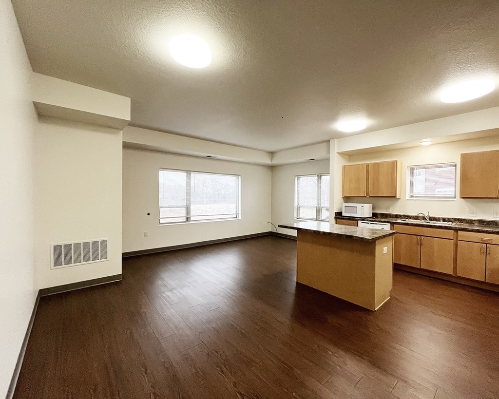 A kitchen with wooden floors and white walls.