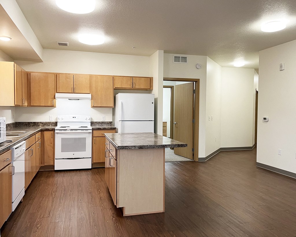 A kitchen with wooden cabinets and a white stove top oven.