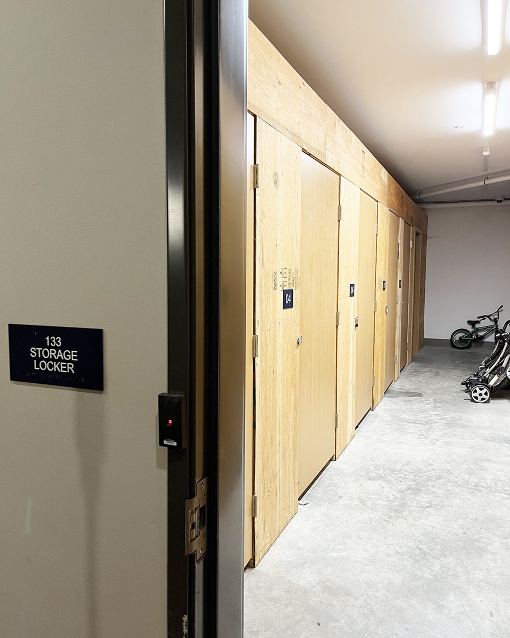 A storage locker room with doors and a sign that says "133 Storage Locker".