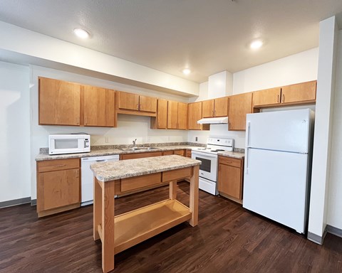 A kitchen with wooden cabinets and a white refrigerator.