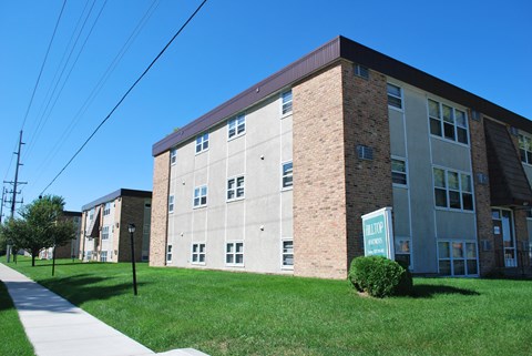 a brick building with a green lawn in front of it