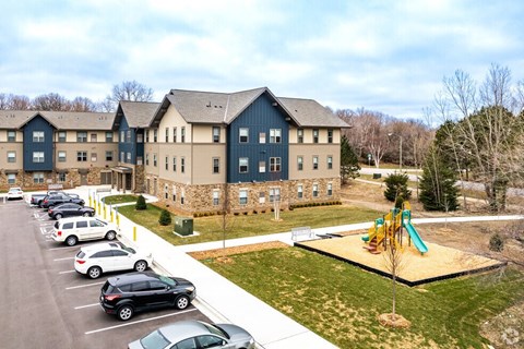 A large building with a playground in front of it.