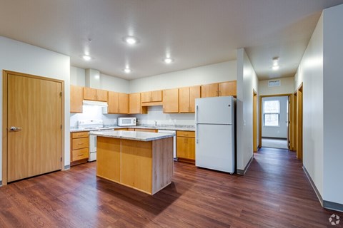 A kitchen with wooden cabinets and a white fridge.